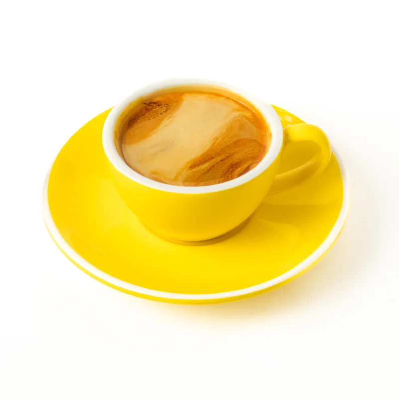 Café americano en taza amarilla con platillo a juego