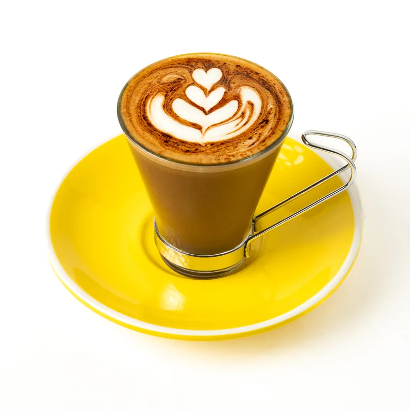 Mocca en vaso de cristal con asa metálica y un tulipán dibujado en la espuma