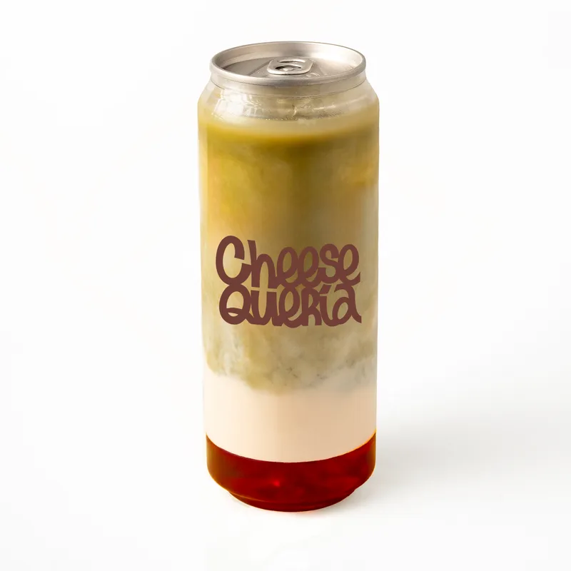 Raspberry matcha: matcha, leche de avena y frambuesa roja en el fondo, en lata transparente con el logo de Cheesequería