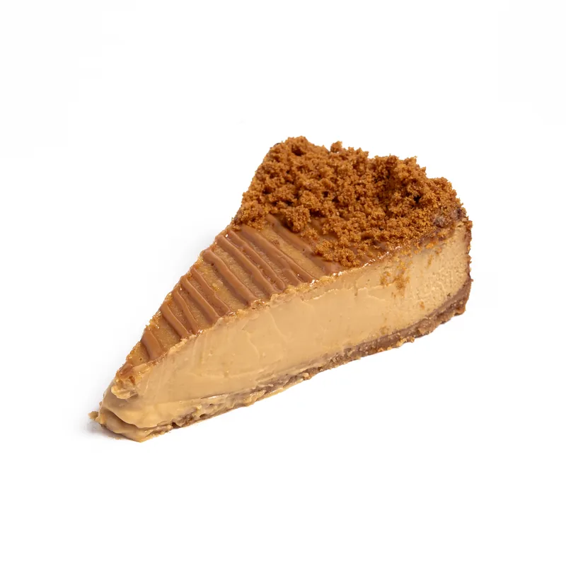 Porción de tarta de queso de caramelo salado con cobertura de caramelo y galleta triturada en el borde