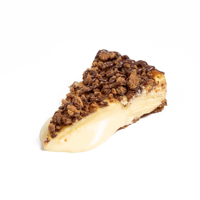 Porción de tarta de queso de Chips Ahoy con galleta triturada e hilos de chocolate, de interior cremoso