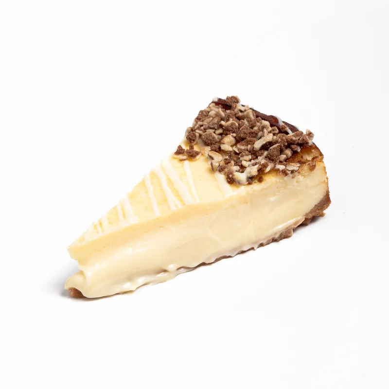 Porción de tarta de queso de Filipinos blancos con hilos de chocolate blanco y Filipinos troceados