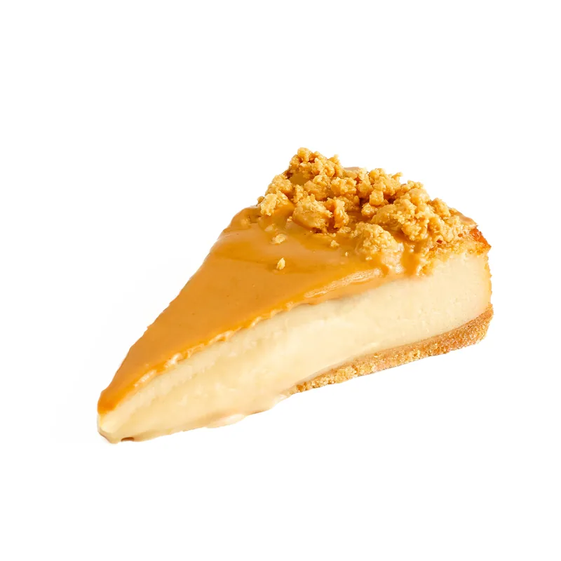 Porción de tarta de queso de turrón con cobertura color tostado y trocitos dorados por encima
